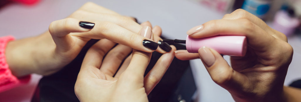 Manicure. Beauty saloon. Close-up.Apply black nail polish.